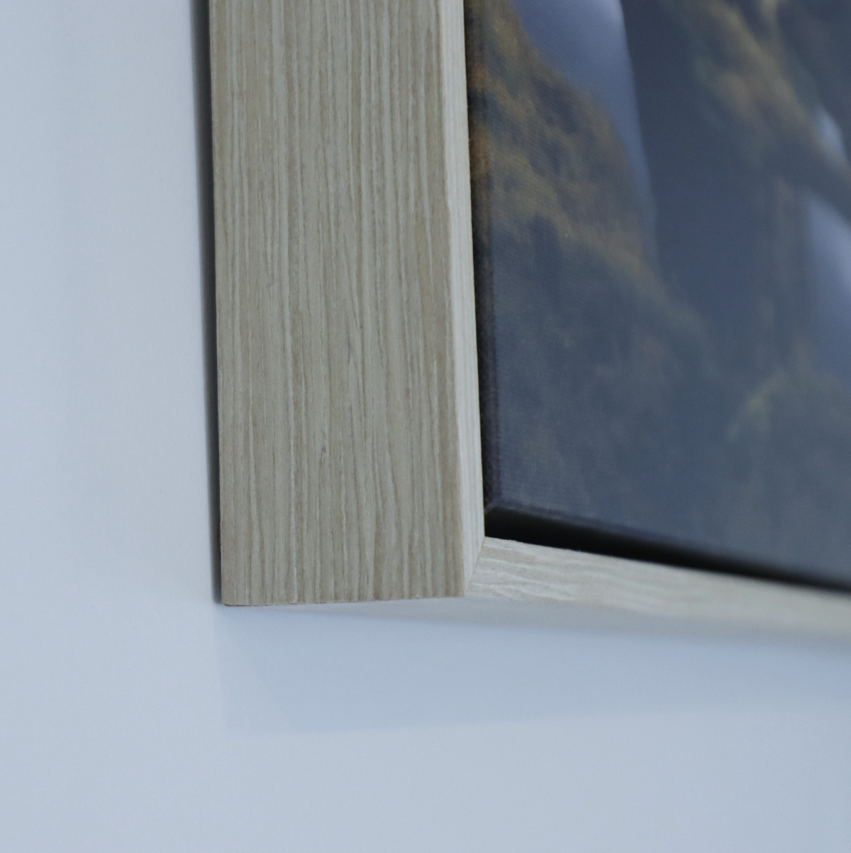 Close-up of a wooden float frame of canvas print corner on a white wall (NZ/AUS colour) 