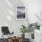 Lounge room with framed Moody storm clouds, sun-lit peak over Lakeside peaks in Queenstown New Zealand