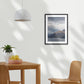 Dining room with framed Moody storm clouds, sun-lit peak over Lakeside peaks in Queenstown New Zealand