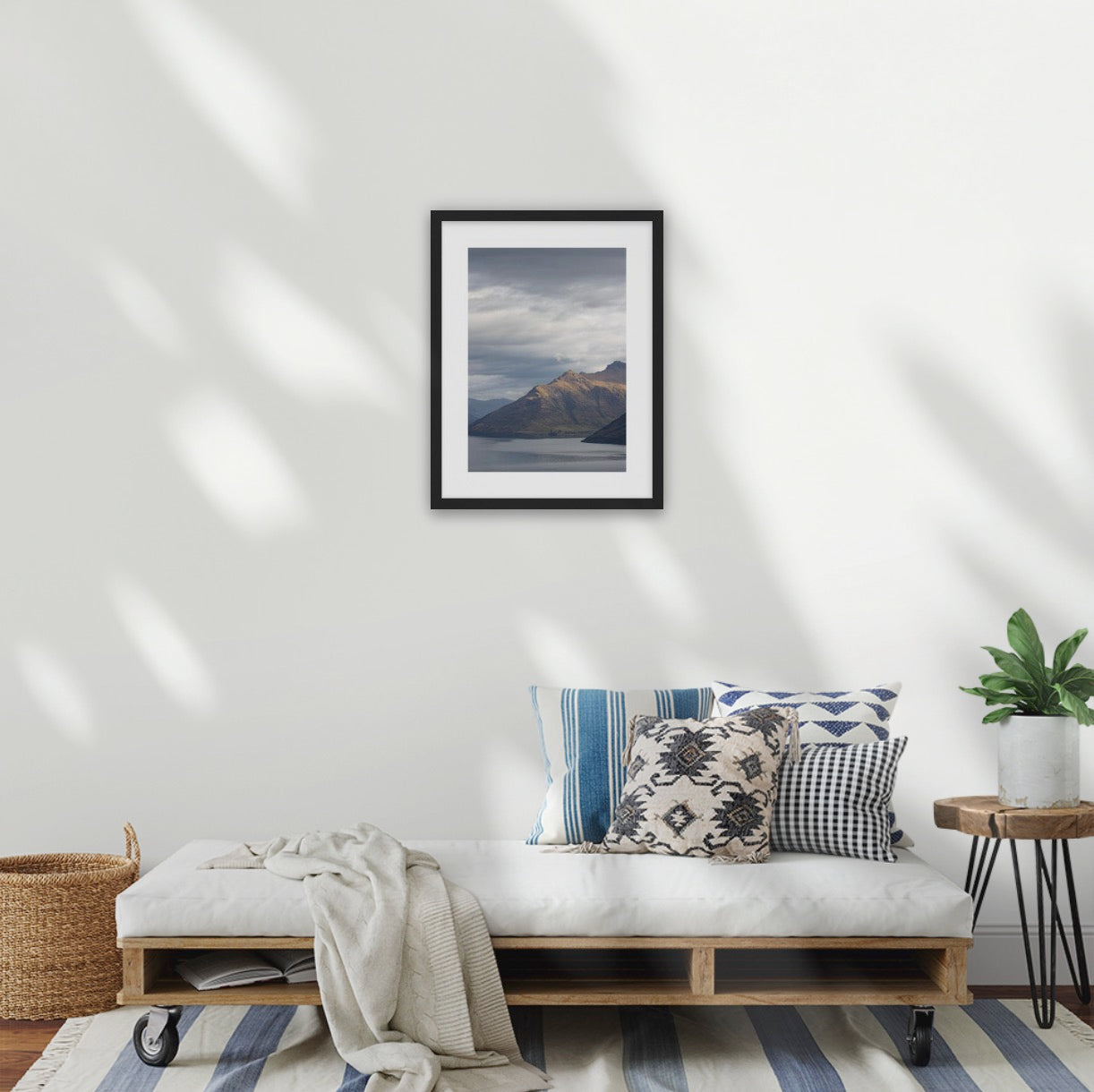 Lounge room with framed Moody storm clouds, sun-lit peak over Lakeside peaks in Queenstown New Zealand