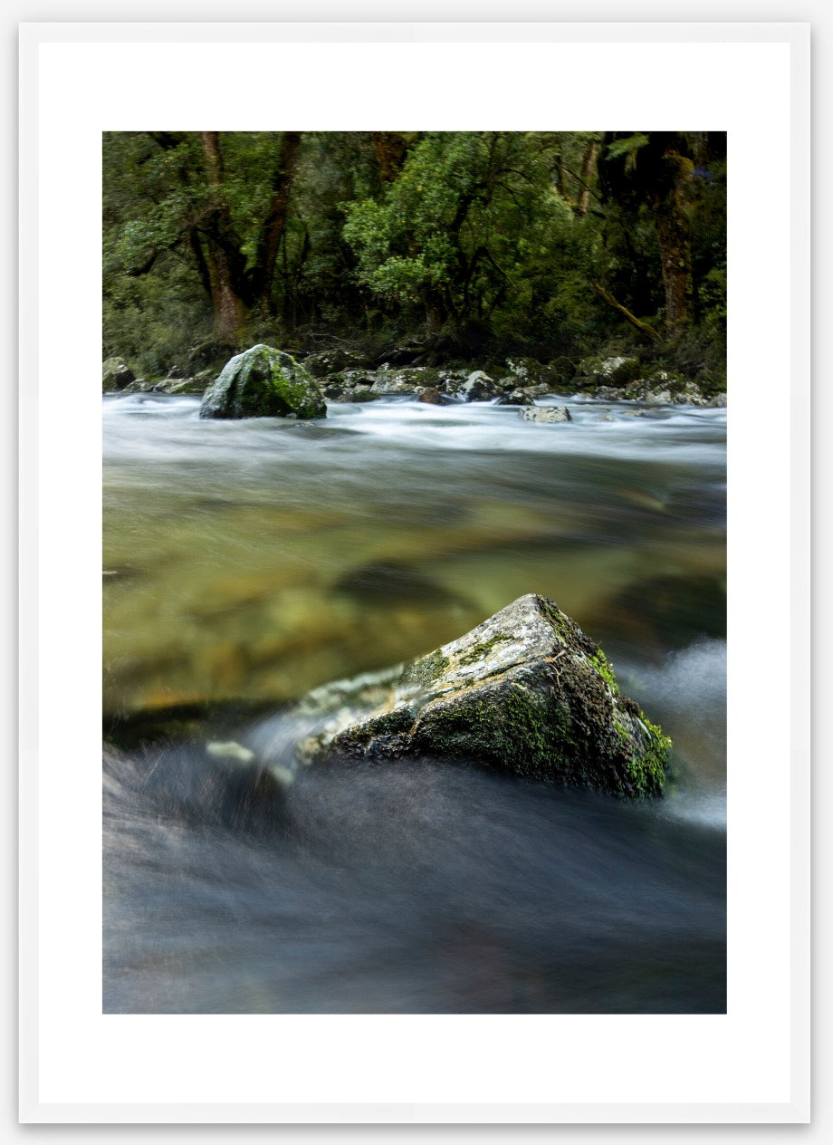 Milford Track, river rocks in the clear wilderness waters of a moody Clinton River, Fiordland, New Zealand.