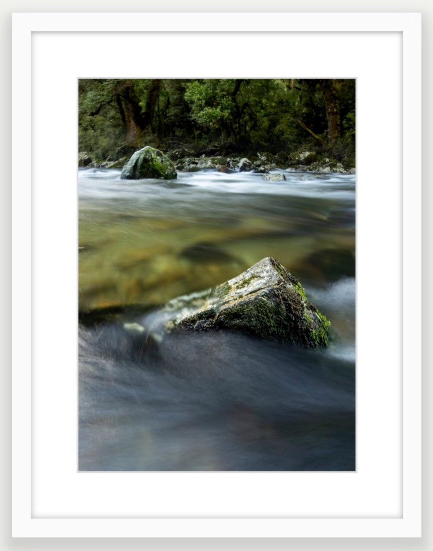 Milford Track, river rocks in the clear wilderness waters of a moody Clinton River, Fiordland, New Zealand.