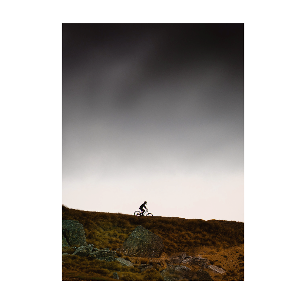 Mountain biker against a dark stormy sky